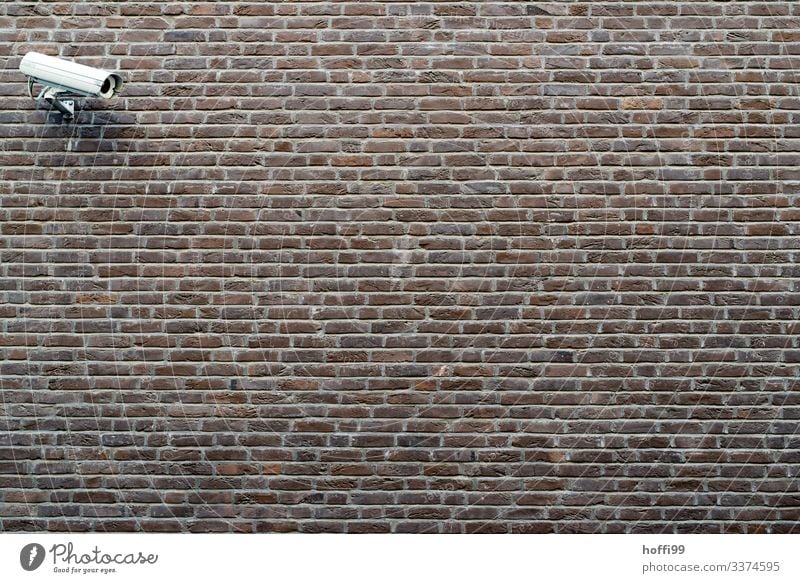 Überwachungskamera an Aussenmauer Gebäude Mauer Wand Fotokamera Backstein Linie Streifen bedrohlich dunkel Stadt Sicherheit Schutz Wachsamkeit Angst
