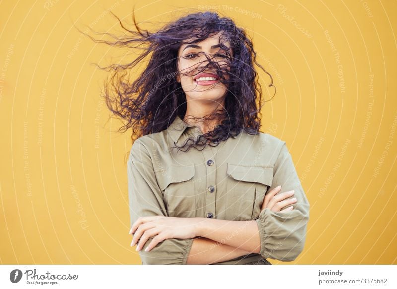 Arabische Frau mit lockigem Haar im Gesicht Behaarung arabisch Frisur Lächeln schön Mädchen Schönheit jung eine Mode copyspace nahöstlich gelb grün Model