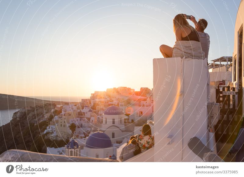 Ein Paar beobachtet den Sonnenuntergang auf der Insel Santorin, Griechenland. Lifestyle Glück schön Erholung Ferien & Urlaub & Reisen Sommer Meer Fotokamera