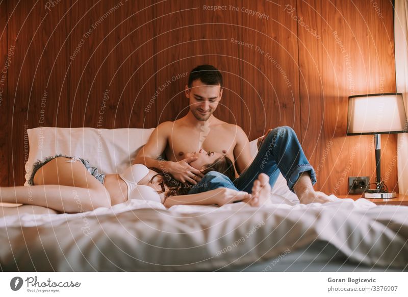 Junges, glückliches, verliebtes Paar, das auf dem Bett liegt und sich gegenseitig genießt Freude Glück Erholung Schlafzimmer Mensch Junge Frau Jugendliche