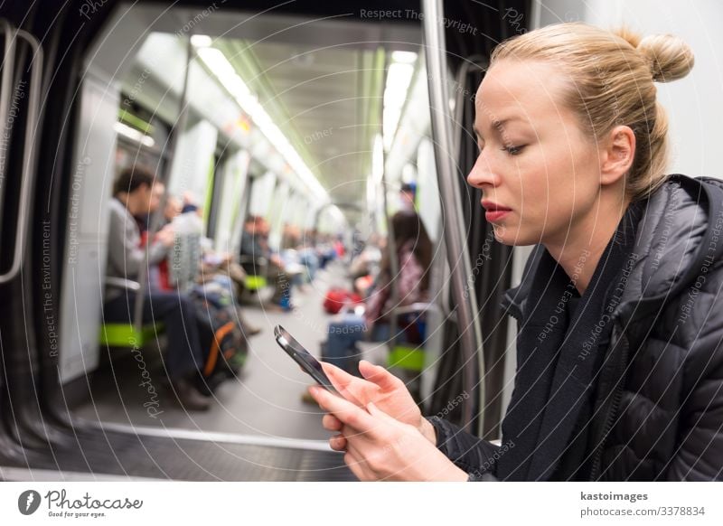 Ein junges Mädchen liest in der U-Bahn vom Bildschirm eines Mobiltelefons. Lifestyle Ferien & Urlaub & Reisen Ausflug Dekoration & Verzierung Business Telefon