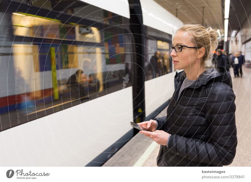 Frau mit einem Handy wartet auf die U-Bahn. Lifestyle Ferien & Urlaub & Reisen Ausflug Dekoration & Verzierung Telefon PDA Mensch Erwachsene Verkehr Eisenbahn