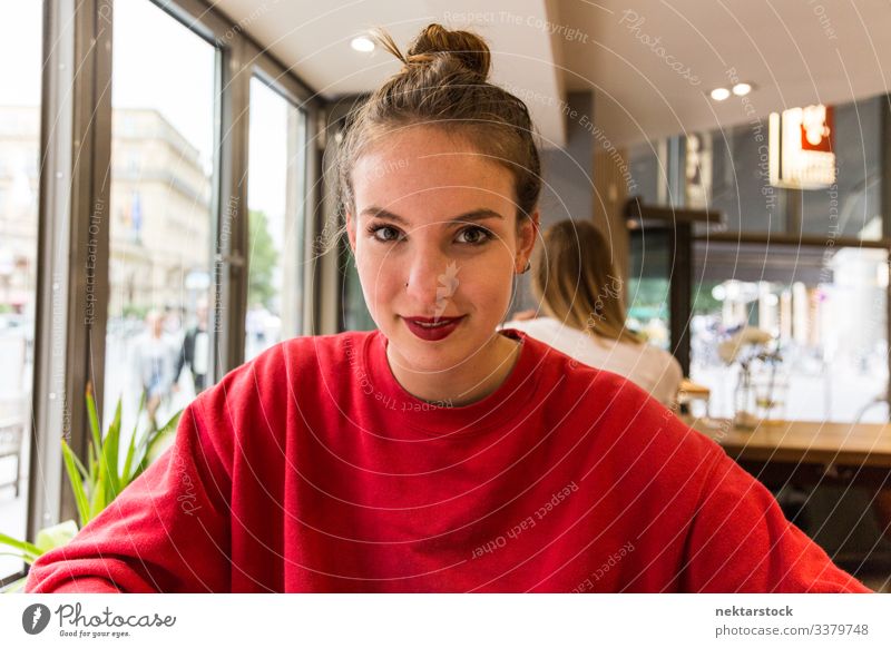 Junge kaukasische Frau lächelt vor der Kamera im Coffee Shop Lächeln Mädchen junger Erwachsener Jugendkultur Tag weibliche Schönheit schöne Frau