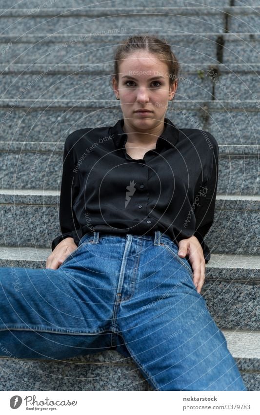 Junge Frau sitzt gemächlich auf Freilufttreppen und schaut in die Kamera sich zurücklehnen Mädchen Freitreppe Murmel Stein in die Kamera schauen entspannt