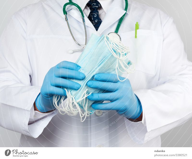 Arzt im weißen Kittel Behandlung Krankheit Medikament Labor Arbeit & Erwerbstätigkeit Beruf Krankenhaus Mann Erwachsene Hand Handschuhe blau Schutz Mundschutz