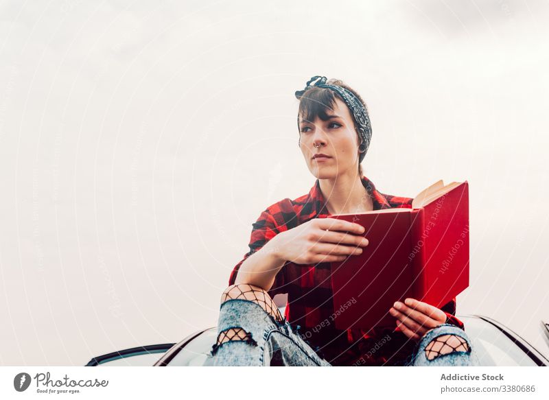Nachdenkliche Gelegenheitsfrau mit Buch am Meeresufer Frau PKW lesen Sitzen lässig Teenager Hipster nachdenklich träumen wehmütig besinnlich Verkehr Ausflug