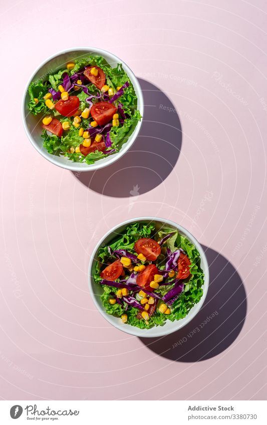 Frischer Kopfsalat mit Kirschtomaten Salatbeilage Lebensmittel Salatkopf Mais rote Zwiebel Sonnenlicht frisch Gemüse Veganer Vegane Ernährung gesunde Ernährung