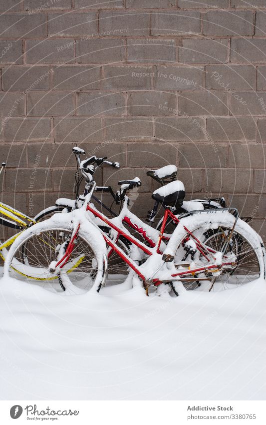 Mit Schneefahrrädern neben einer Steinmauer bedeckt Fahrrad Wand Winter Straße Verkehr farbenfroh Fahrzeug Zyklus reisen Außenseite Gebäude Tourismus Schwedisch