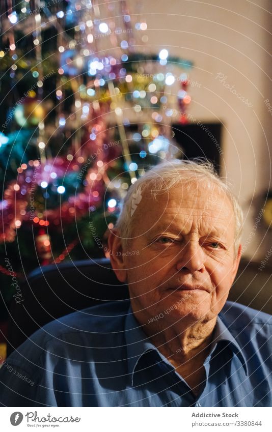 Positiver männlicher Rentner sitzt am Heiligabend zu Hause Mann lässig Senior heimwärts Weihnachten Windstille sich[Akk] entspannen positiv sitzen wohnlich