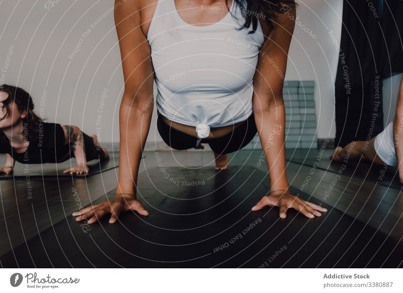 Frau praktiziert Yoga in fliegender Taubenstellung üben fliegende Taube Pose Körper Barfuß Training einbeiniges Brett Klasse Fitness Atelier positionieren