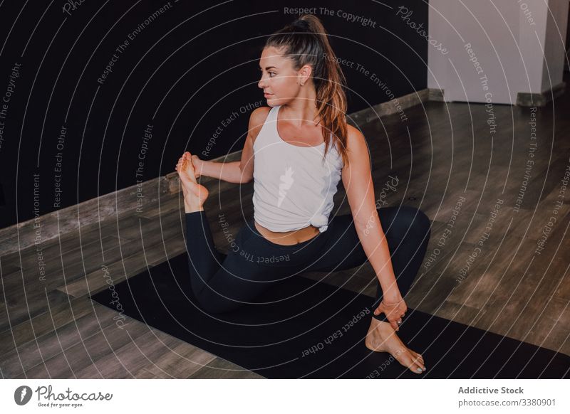 Schlanke junge Sportlerin macht Yoga-Übung einbeinige Königstaube Pose zwei in modernem Studio Frau Athlet Dehnung beweglich Einbeinige Königstauben-Pose