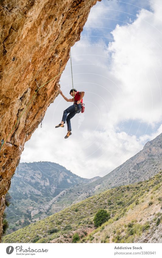 Mutige Bergsteigerin an Klippe hängend Aufsteiger Frau Alpinist aufsteigen Berge u. Gebirge Gelände Abenteuer extrem Risiko Herausforderung Adrenalin Freiheit