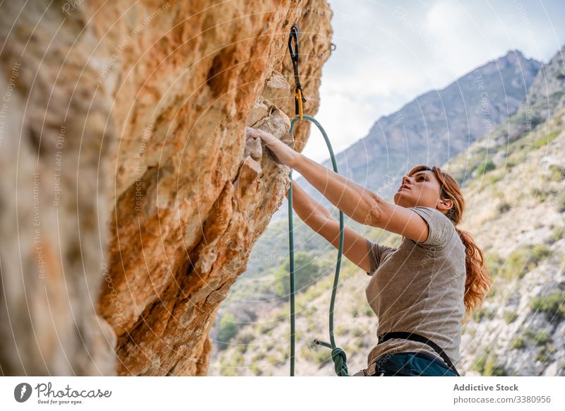 Aktive Bergsteigerin beim Aufstieg am Fels Aufsteiger aufsteigen Klippe Frau Alpinist Berge u. Gebirge üben Klettern aktiv Bergsteigen Risiko reisen Mut