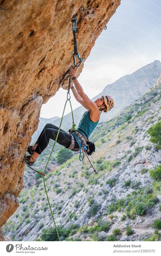 Konzentrierte junge Bergsteigerin, die im Sommer auf eine Klippe steigt Aufsteiger aufsteigen Frau Alpinist Berge u. Gebirge üben Klettern aktiv Bergsteigen