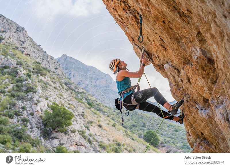 Konzentrierte junge Bergsteigerin, die im Sommer auf eine Klippe steigt Aufsteiger aufsteigen Frau Alpinist Berge u. Gebirge üben Klettern aktiv Bergsteigen