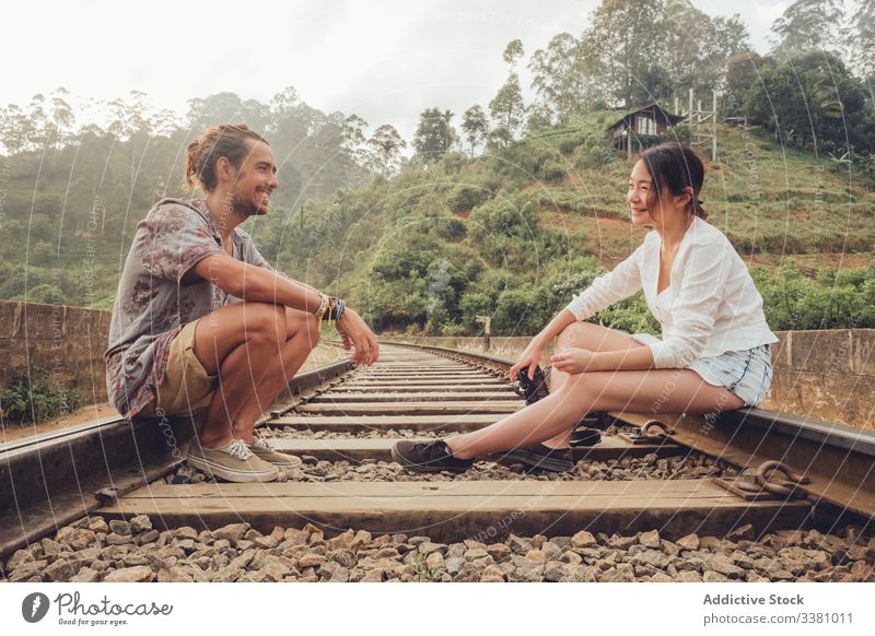 Frau fotografiert Mann mit Kamera, während sie auf einer Eisenbahnstrecke sitzt Paar reisen fotografieren tropisch exotisch Zusammensein erkunden Gedächtnis
