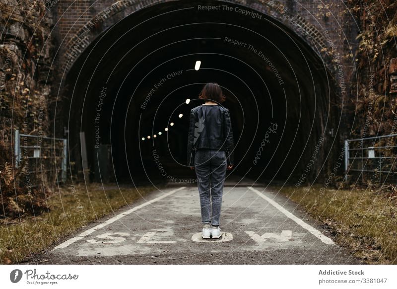 Frau steht vor dunklem Tunnel auf der Strasse Stollen Straße dunkel Illumination Aufschrift langsam reisen Architektur Gebäude alt Spaziergang Stein Weg antik