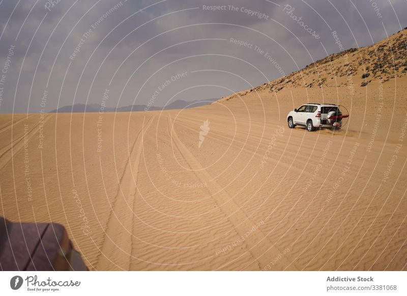 Dramatische Landschaft eines Fahrzeugs auf einer Wüstenstraße wüst Straße PKW Laufwerk stürmisch Himmel Verkehr reisen Reise Natur Sand dramatisch Abenteuer
