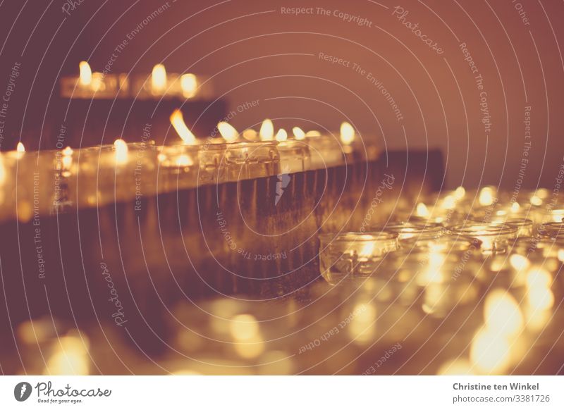 Kerzenaltar mit brennenden Teelichtern in Kerzengläsern Kirche Kerzenschein Kerzenstimmung Kerzenflamme Kerzenglas glänzend leuchten ästhetisch heiß hell nah