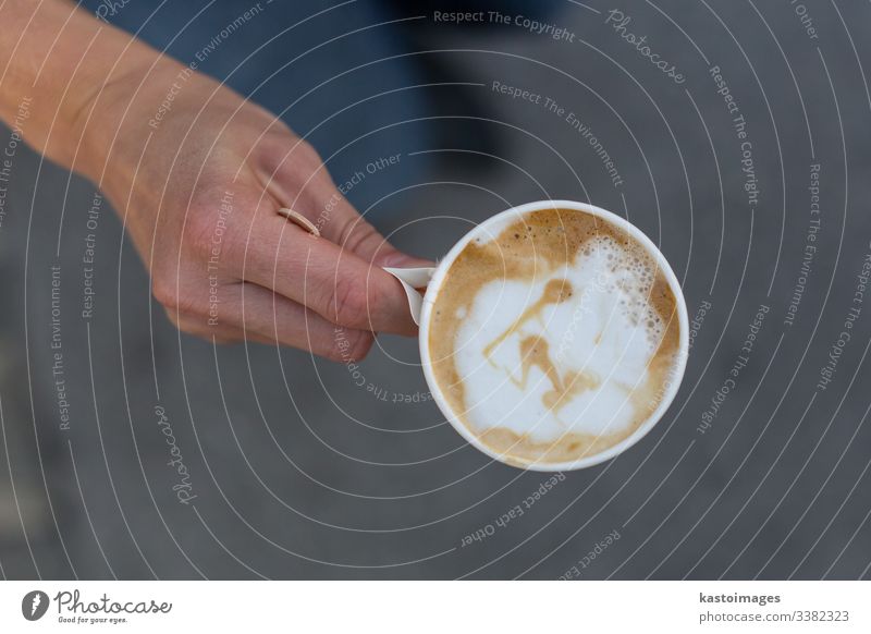 Hand hält eine Tasse Kaffee zum Mitnehmen. gehen Sie Latte Papier Kunst weg Top Ansicht Kunststoff trinken Einwegartikel Cappuccino Café weiß Arbeit schwarz