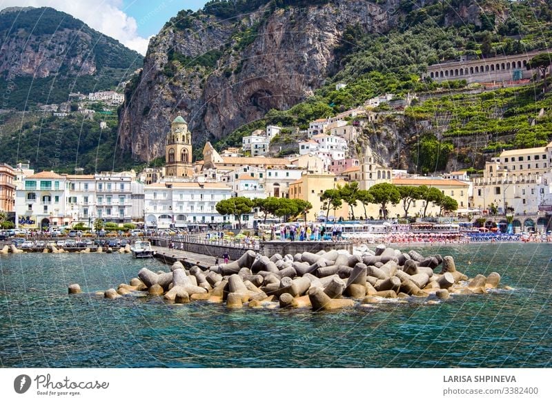 Luftaufnahme des kleinen Hafens des Dorfes Amalfi mit türkisfarbenem Meer und bunten Häusern an den Hängen der Amalfiküste mit dem Golf von Salerno, Kampanien, Italien.