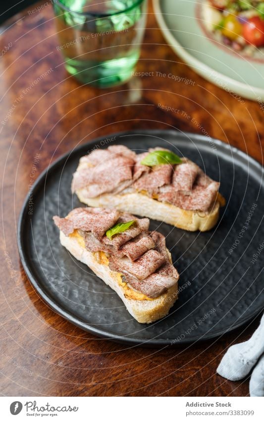 Frische Schinken-Sandwiches auf schwarzer Platte im Restaurant Belegtes Brot Zuprosten Lebensmittel geschmackvoll lecker Mahlzeit frisch Snack Feinschmecker