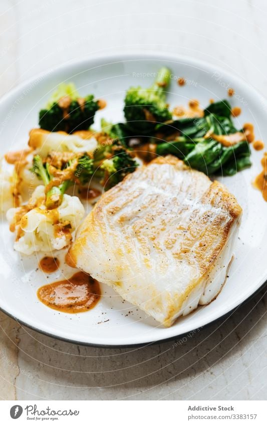 Fisch mit Gemüse und Sauce auf dem Teller Brokkoli grün Lebensmittel frisch Feinschmecker lecker geschmackvoll Küche Speise Gesundheit Bestandteil Portion