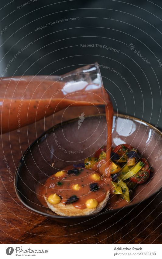 Kotelett in Soße mit Tomaten- und Kartoffelgarnitur Fleisch Speise Hohe Küche Restaurant eingießen Teller Schalen & Schüsseln farbenfroh Saucen Kraut Grün