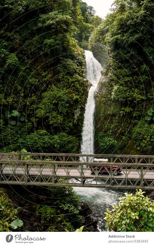 Retro-Wagen auf der Brücke beim Wasserfall PKW Dschungel Mitfahrgelegenheit retro grün Natur Costa Rica Verkehr Fahrzeug Auto altehrwürdig strömen fließen Fluss