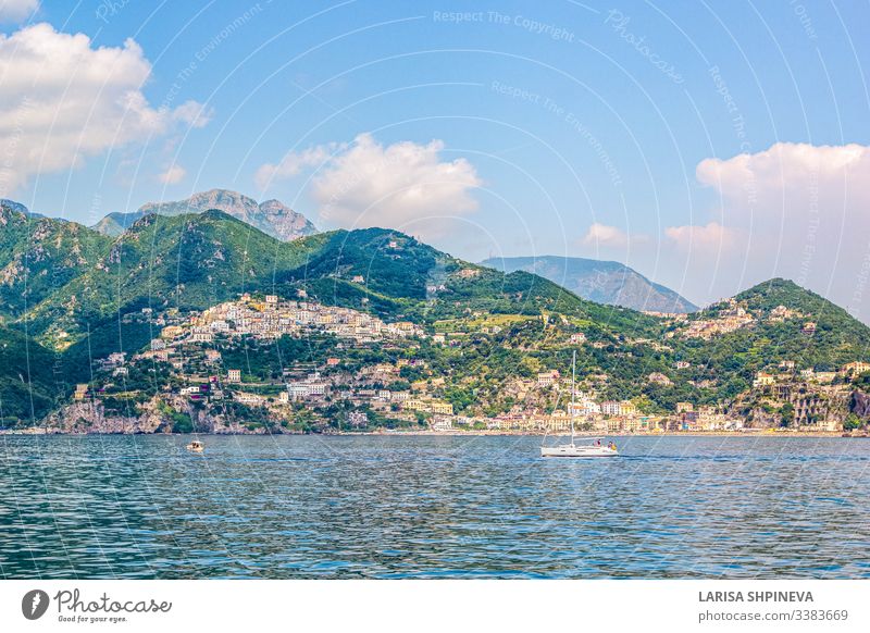 Panoramablick auf den kleinen Hafen des Dorfes Amalfi mit türkisfarbenem Meer und bunten Häusern an den Hängen der Amalfiküste mit dem Golf von Salerno, Kampanien, Italien.