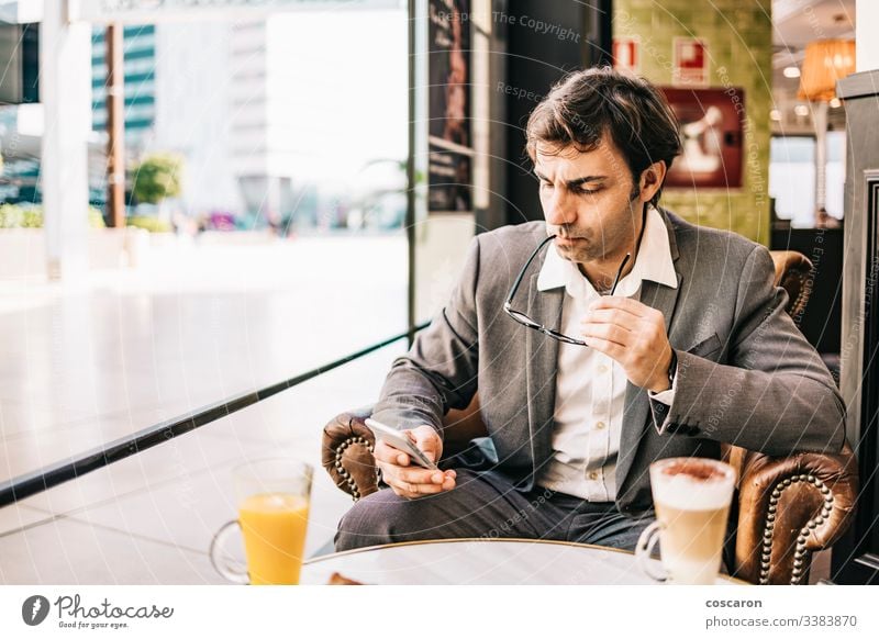 Besorgter Geschäftsmann beim Frühstück an der Bar Erwachsener Business Café Funktelefon Großstadt Kaffee Computer Textfreiraum deprimiert Depression Unbehagen