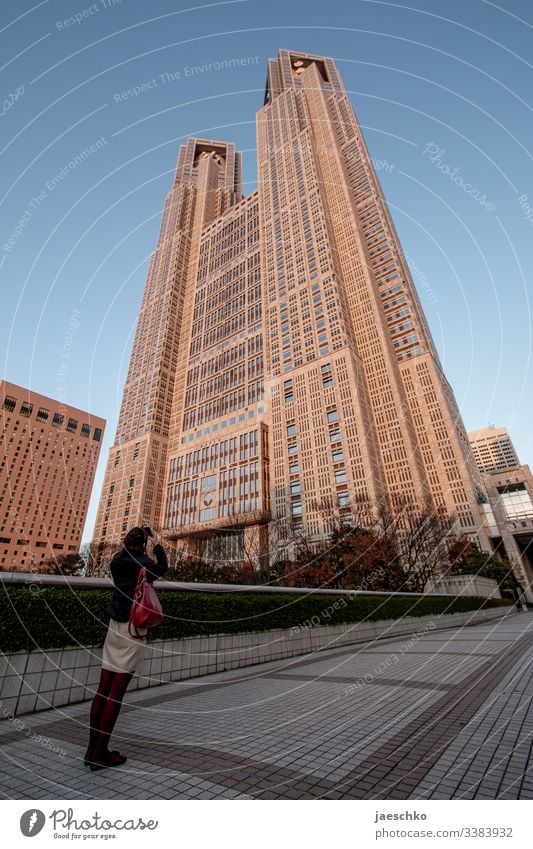 Junge Frau fotografiert Hochhaus in Japan Architektur Tokio Tokyo Rathaus Wolkenkratzer Tourismus Stadtrundgang hoch Haus futuristisch Stadtzentrum Bauwerk