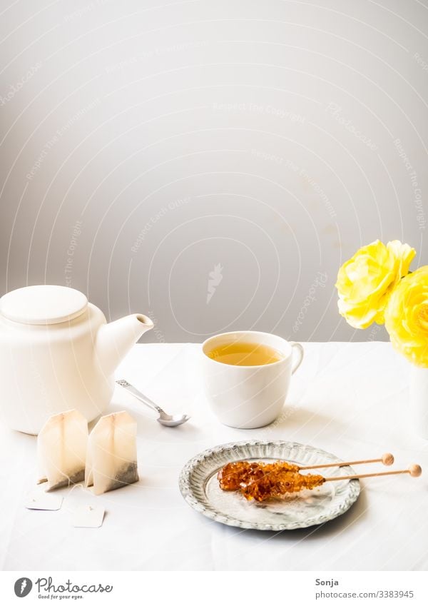 Teepause mit Kräutertee und Kandiszucker Fahne Frühling kräutertee kandiszucker teekanne Zauberstab weiss teebeutel löffel tasse heiß getränk süß tischtuch