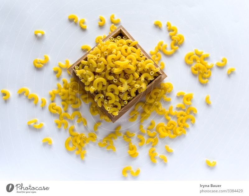 Ungekochte gelbe Nudeln auf dem weißen Grund. Spätzle Speisekarte Lebensmittel Küche Makkaroni Italienisch Essen roh Penne Gesundheit Textur vereinzelt