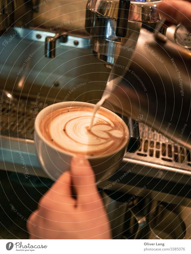 Milch, die Milchkaffee-Kunst in die Kaffeetasse gießt Latte Getränk heiß Café Latte Tasse auf Espresso-Basis Kaffeehaus doppelter Espresso Latte Art Heißgetränk