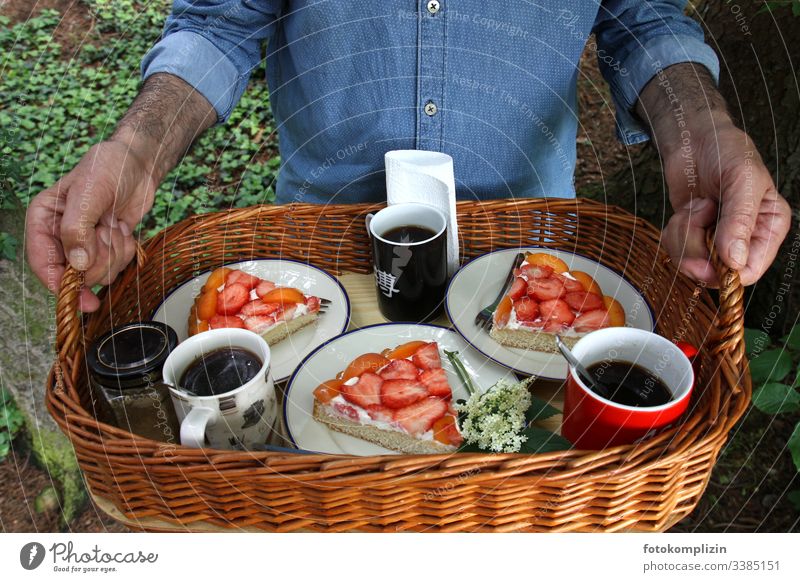 kaffee und kuchen auf tablett im grünen Picknickkorb Kaffeetrinken Kuchenstücke Erdbeerkuchen Kaffeepause Tablett Ernährung Lebensmittel nachmittagskaffee