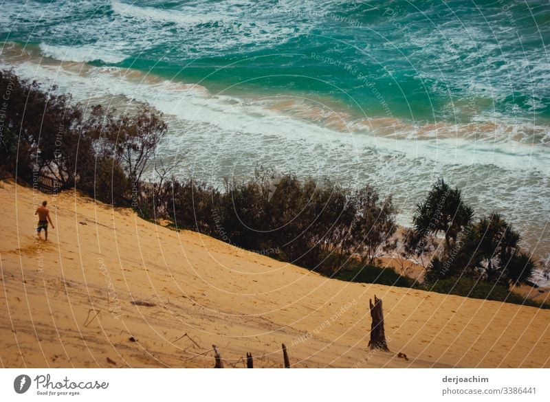 Ein Mann geht die Große Sanddüne hinunter zum Meer. Wasser Brandung Wellen Gischt Natur Außenaufnahme Küste Farbfoto Urelemente Textfreiraum oben Umwelt wild