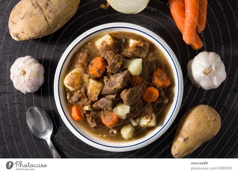 Irischer Rindfleischeintopf mit Karotten und Kartoffeln auf schwarzem Hintergrund - Draufsicht Möhre gekocht Speise Lebensmittel Gulasch Kraut selbstgemacht