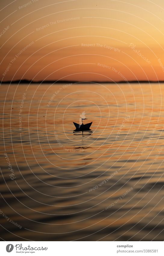 Papierschiff im Sonnenuntergang auf einem See reise urlaub reisen papierschiff gesundheit alternativmedizin wellness wohlgefühl ruhig freizeit & hobby spielen