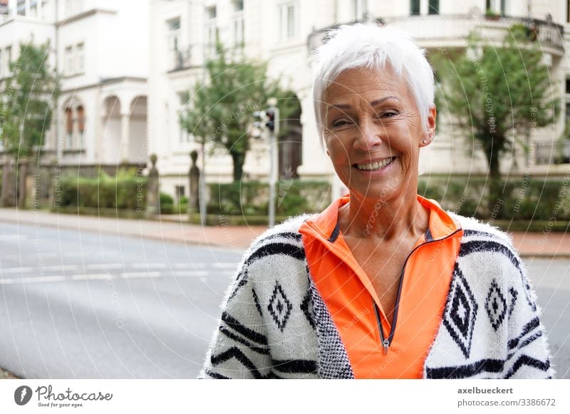 glückliche reife Frau auf der Straße Senior Dame Glück Lächeln außerhalb Erwachsener Großstadt urban Bestseller 60 trendy sportlich kurz weiß Behaarung