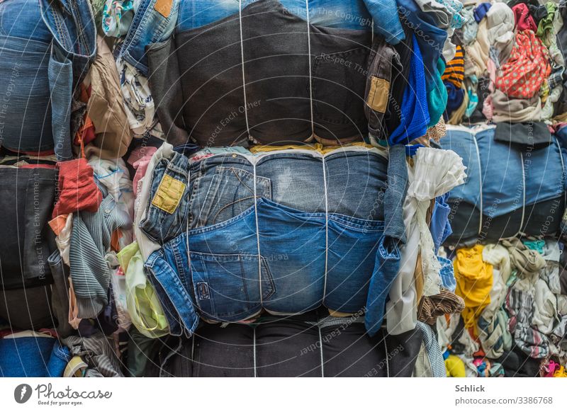 Ballen aus gebrauchten Textilien besonders Jeans als Hintergrundbild Sekundenzeiger viele Textilindustrie Recyclinghof bunt gemischt Bekleidung Stoff Mischung