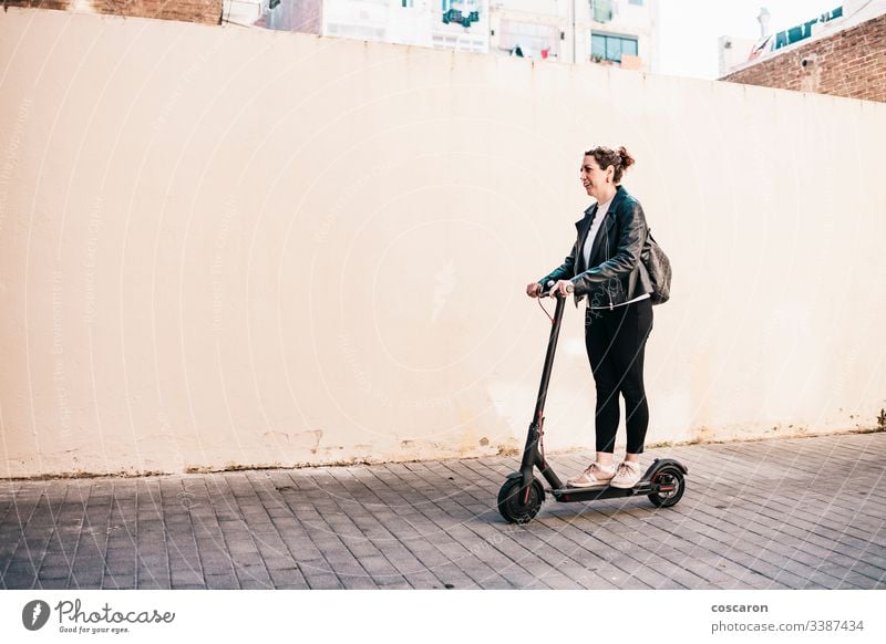 Frau mittleren Alters auf einem Elektroroller aktiv Erwachsener allein attraktiv Hintergrund Holzplatte Business heiter Großstadt fahren e-Scooter Öko