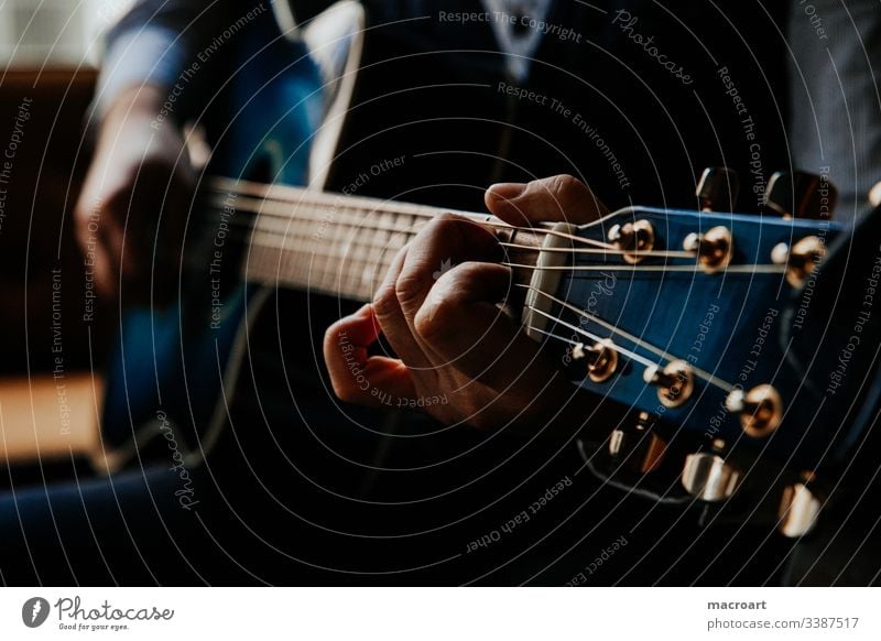 Gitarre gitarre westerngitarre gitarrenspieler griffbrett stahlsaiten blau hände hand mann greifen akkorde nahaufnahme