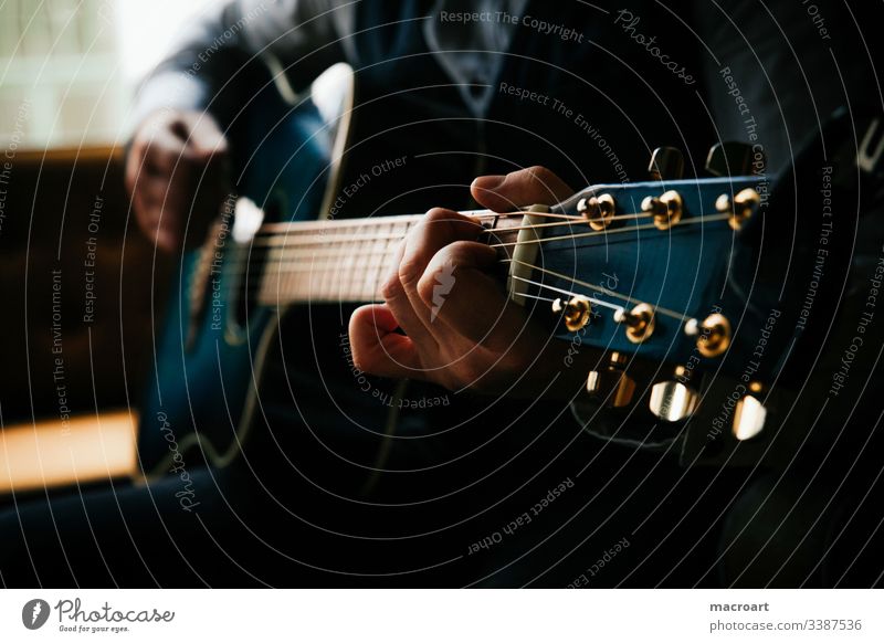 Gitarre gitarre westerngitarre gitarrenspieler griffbrett stahlsaiten blau hände hand mann greifen akkorde nahaufnahme