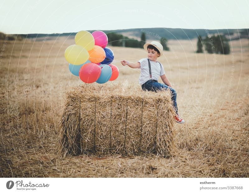 glückliches Kind mit Luftballons auf dem Feld Ballons Abenteuer entdecken Freiheit Korn Gras Wachstum Fröhlichkeit Glück Hut Selbstständigkeit Freude Lifestyle