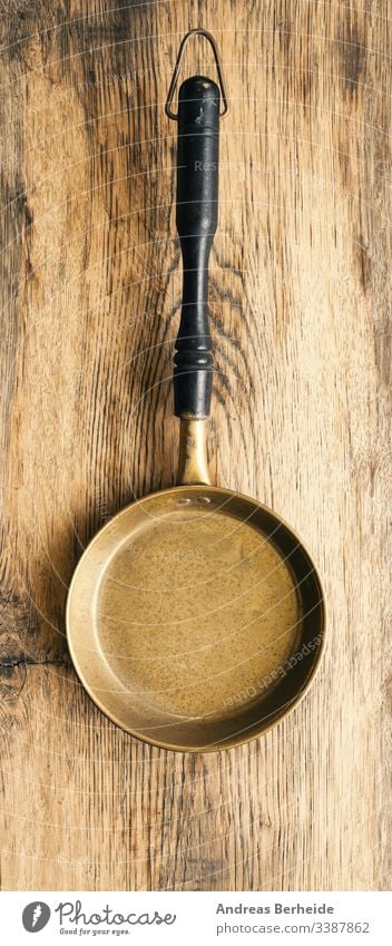 Alte gebrauchte Pfanne auf rustikalem Holz Hintergrund Messing Nahaufnahme Essen zubereiten heimisch leer Gerät Lebensmittel Handgriff Gesundheit Haushalt