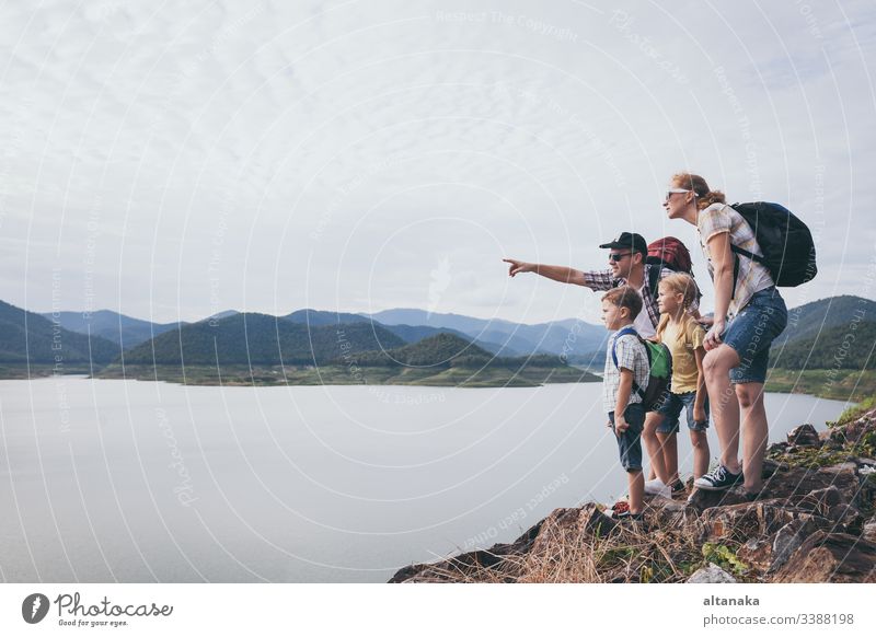 Glückliche Familie, die tagsüber in der Nähe des Sees steht. im Freien reisen Kind Menschen Sohn Lifestyle Urlaub Junge Natur Vater Zusammensein aktiv Sommer