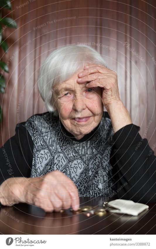 Ältere Frau, die am Tisch sitzt und Geld in ihrer Brieftasche zählt. Senior Rentnerin älter Armut Ruhestand alt leer Münzen Hintergrund unglücklich pleite