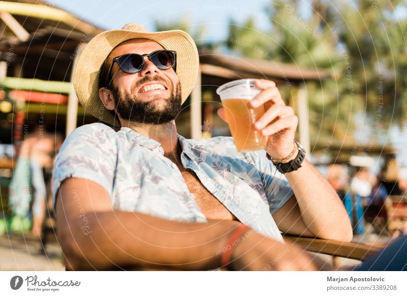 Junger, gut aussehender Mann genießt Bier in Strandbar 30s Erwachsener Alkohol Bar bärtig Getränk lässig Kaukasier heiter jubelt cool Ausflugsziel trinken