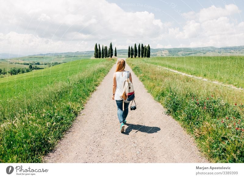 Junge Reisende zu Fuß in der Toskana schön Fotokamera lässig Land Landschaft Zypresse Zypressen Traumland genießend Europa Europäer Entdecker Frau Mädchen grün